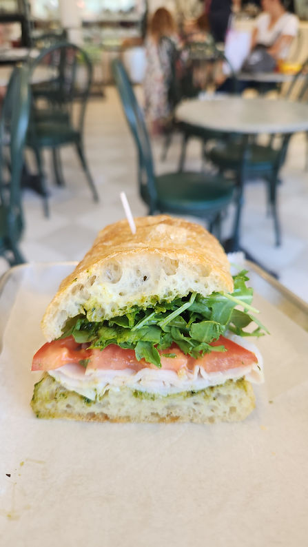 Delicious sandwich with tomato and arugula; Runcible Spoon Bakery setting.